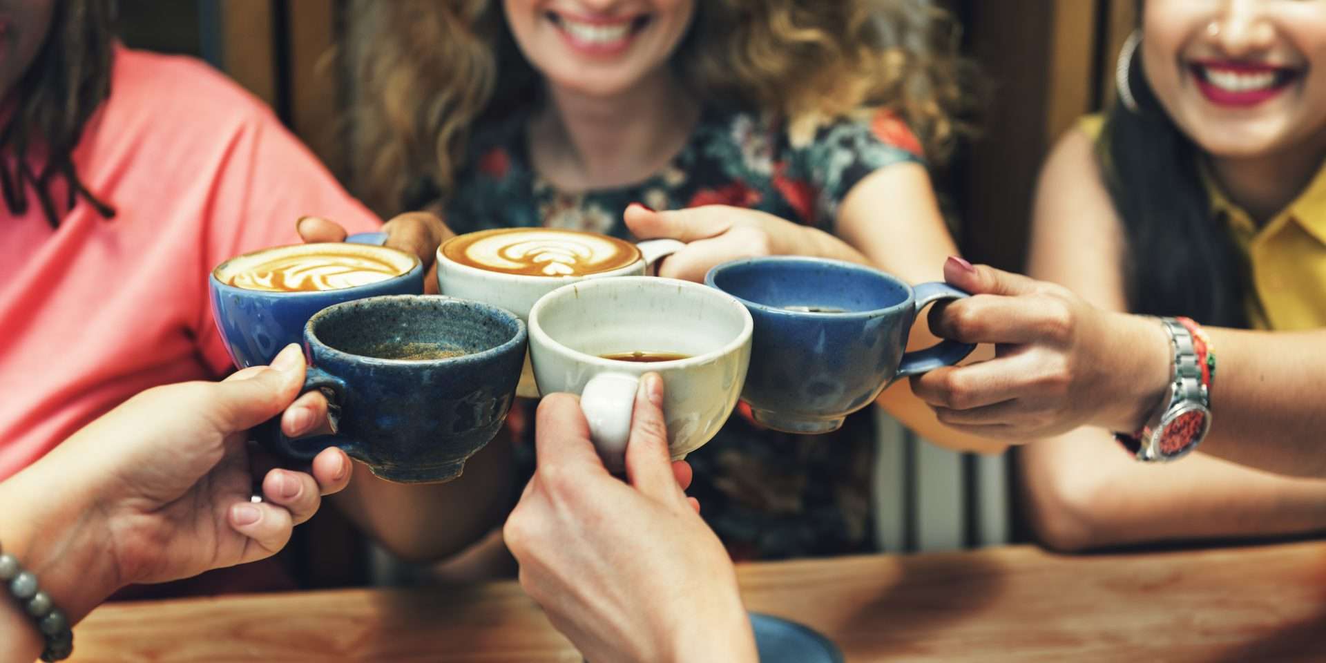 a group of people holding cups of coffee